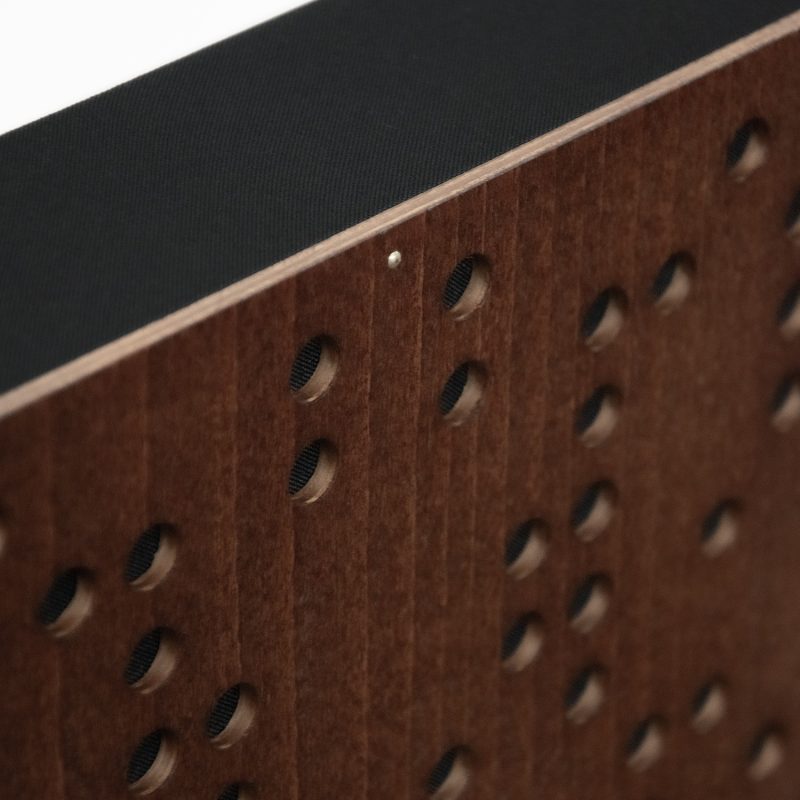 A detail of the Binary Diffuser's corner - the Mahogany front, the perforation and the black upholstery fabric